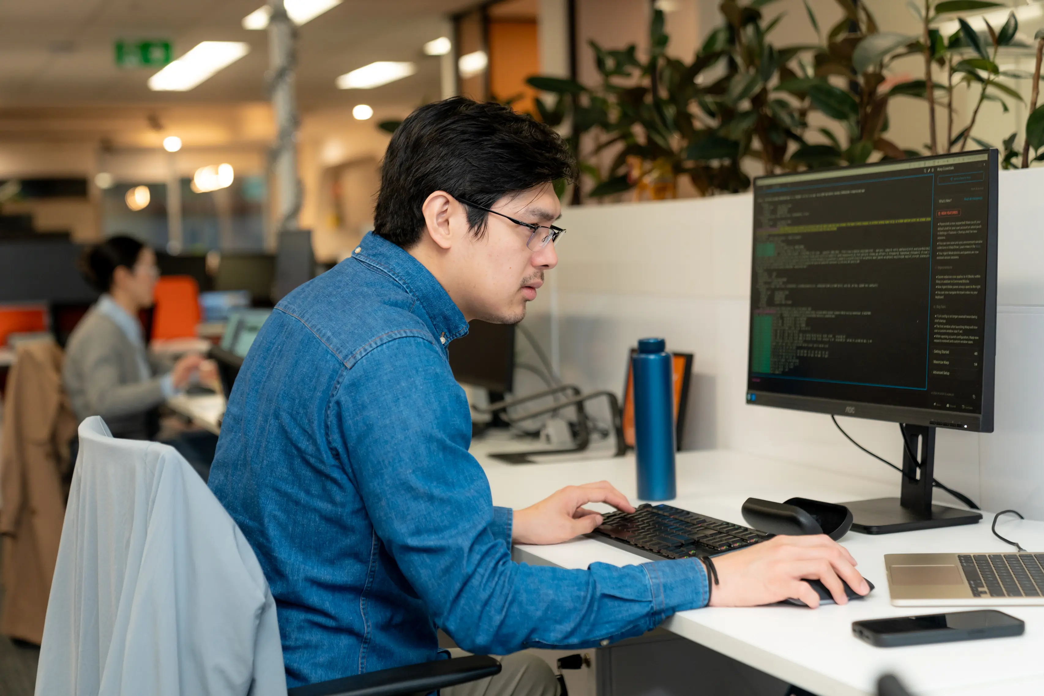 web development agency, man sitting at a desk with computer displaying website code