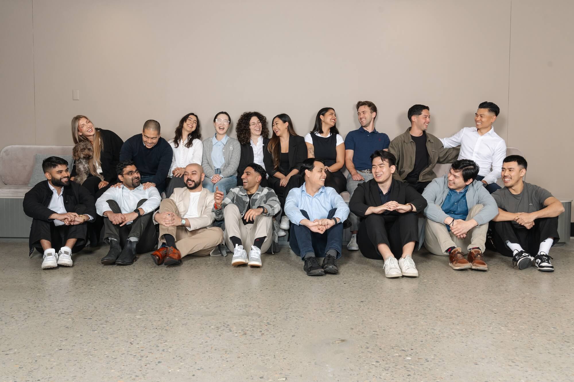 a team of young professionals sitting down and laughing and having fun together